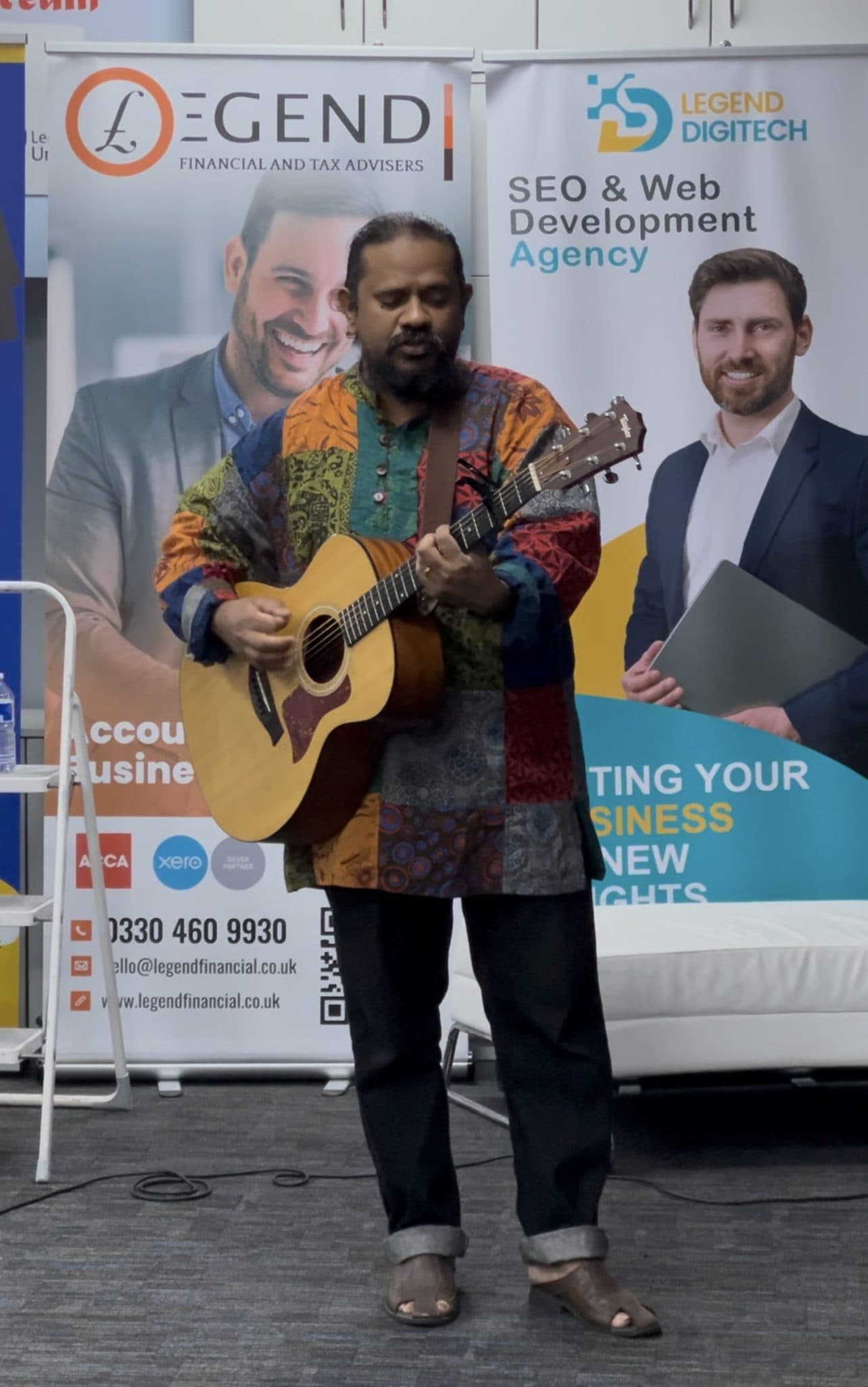A performer playing acoustic guitar at WIC's Diwali celebration